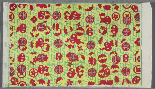 Decorative paper with auspicious motifs, Chinese, graphic print, 20th century, China, graphic, height 38.0 cm, width 23.5 cm, A rectangular sheet with a patterned central area bordered by a narrow margin, featuring a bright yellow background overlaid with a turquoise-green maze-like geometric pattern and scattered red decorative motifs; the red motifs include circular medallions, stylized floral and petal shapes, and rounded abstract forms, with occasional small green accents where the background shows through; the outer edge shows off-white paper margins with slight creases and a torn corner, and the overall color palette is yellow, red, turquoise-green, and off-white.