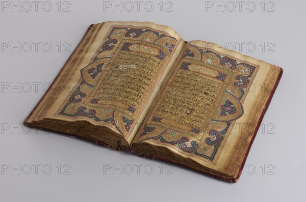 Quranic manuscript, unknown creator/calligrapher, ; Islamic art, Ottoman dynasty 1299–1922; Arabic manuscript; written in Nashi script; illuminated; contains two pages for Surah XVII and sixteen later leaves; paper: striated, smoothed, cream, saffron-colored; 18th century, with 19th-century additions; Central Asia origin, Khiva; manuscript; h 23.0 cm, w 14.5 cm, thickness 4.2 cm., An open ornate book lies on a pale gray surface, showing a spread of aged, cream-colored pages with decorative borders and dense horizontal lines of dark script; the page edges are browned and worn, and the book's cover appears to be a faded reddish-brown. The ornamental borders include a palette of gold, dark blue, green, pink, and black with intricate floral and geometric motifs, and the central text blocks are framed by thin colored lines. The spine area shows darker brown aging and a few creases, and the pages have slightly uneven, wavy edges.