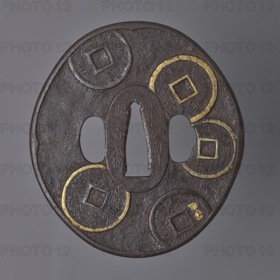 Crossguard tsuba, Umetada,  school; Umetada Shigeyoshi, / personal slogans / author. Oval tsuba tatemaru gata with a slightly rounded and raised edge of the uchi kaeshi type, seppa dai oval. Decorated on both sides with a relief motif of Chinese coins, details highlighted with gold inlay using the nunome zôgan technique. 1st half of the 18th century Edo period, 1603–1868, Japan. Materials/function: tsuba sword crossguard, height 8.7 cm, width 7.9 cm, depth 0.3 cm., A round, dark metal object with a slightly irregular rim sits against a gray background; its surface shows a textured, brownish-black patina with areas of worn, metallic sheen and traces of gold-colored inlay forming partial circular outlines and square motifs; there is a central vertical opening flanked by two rounded openings and a few raised circular medallion shapes with carved, linear patterns; the overall appearance is aged and metallic with visible scratches and subtle color variations of brown, black, gray, and gold.