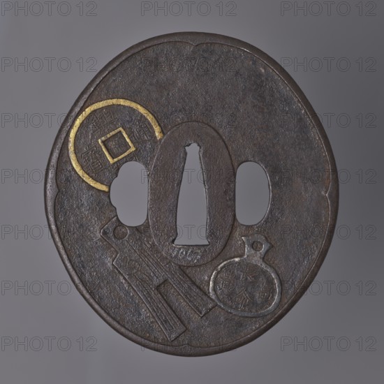 Crossguard tsuba, Umetada school; maker: Umetada Shigeyoshi. Oval tsuba tatemaru gata with a slightly rounded and raised edge of the uchi kaeshi type and an oval seppa dai. Decorated on both sides with a relief motif of Chinese coins, details highlighted with gold inlay using the nunome zôgan technique. 1st half of the 18th century Edo period, 1603–1868, Japan. Material: metal tsuba. Dimensions: height 8.7 cm, width 7.9 cm, depth 0.3 cm., A round, dark brown metal object with a textured surface and an irregular central cutout flanked by two oval openings; the rim is slightly raised and scalloped in places, and there is a partial circular inlay with a metallic gold color near one edge. The surface shows engraved and raised shapes including a tag-like form and a rounded medallion shape, both in the same dark brown metal with areas of lighter brown and a small amount of metallic silver visible on the medallion edge. The background is a smooth gray.
