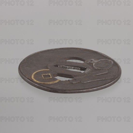 Crossguard tsuba, Umetada,  school, Umetada, Shigeyoshi, / personal slogans / author, Japanese art, Japanese culture, Edo 1603–1868, weapons, cold weapons, swords, katana, sword crossguards, tsuba, coins. Oval tsuba tatemaru gata, with a slightly rounded and raised edge of the uchi kaeshi type, seppa dai oval. Decorated on both sides with a relief motif of Chinese coins, details highlighted with gold inlay using the nunome zôgan technique. 1st half of the 18th century Edo period, Japan. Tsuba; height 8.7 cm, width 7.9 cm, depth 0.3 cm., A round metallic object rests against a plain light gray background, appearing dark brown with areas of lighter brown and small patches of rusty orange. The object has a smooth rim and several openings and raised details, including a rounded central opening and another irregular opening nearby. A segment features a circular motif with a thin ring of gold-colored metal. The surface shows a textured, slightly worn patina with subtle highlights of gray on ...
