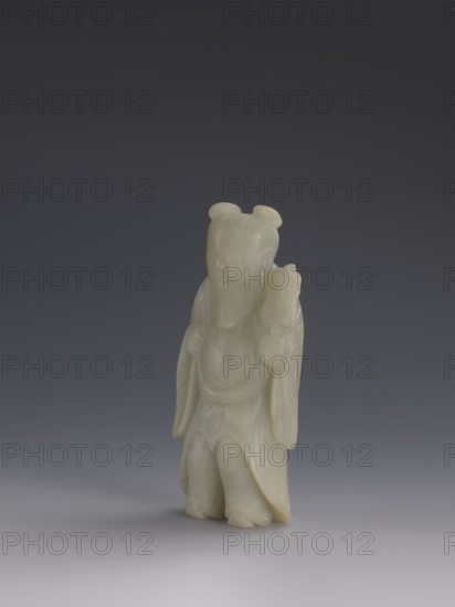 One of the Eight Immortals, gift, Eight Immortals iconography, men, Chinese art, fans, Chinese culture, Qing 1644–1911, 19th century, China, sculpture, height 14.3 cm, width 5.9 cm, A small pale greenish-white stone carving of a standing robed figure with a rounded head and two small top knots, a carved beard, and draped sleeves, shown against a smooth gradient background that transitions from dark gray at the top to lighter gray near the bottom; the figure's surface shows subtle translucency and slight warmer beige tones in some areas.