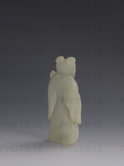 One of the Eight Immortals, Eight Immortals iconography, men, Chinese art, fans, Chinese culture, Qing 1644–1911, 19th century, China, sculpture, height 14.3 cm, width 5.9 cm, A pale greenish-white carved stone figure is shown from the back against a dark gray to muted bluish-gray gradient background, with the figure standing on a lighter gray surface; the figure has a smooth rounded head with two coiled bun shapes, gently sloped shoulders, long draping sleeves or wing-like extensions, and a long robe with faint carved curved lines, and the visible colors are pale greenish-white, dark gray, bluish-gray, and light gray.