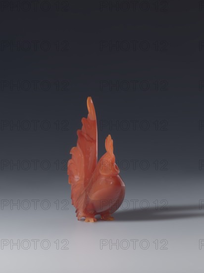 Rooster, unknown creator sculptor, gift; Chinese, Qing 1644–1911; wood sculpture of a rooster; 18th–19th century; height 8.5 cm, width 7.0 cm, depth 2.6 cm; iconography: roosters., A small glossy sculpture of a bird with an upright tail and raised crest stands on a smooth surface; the bird is primarily shades of orange and red with subtle variations and a few areas of lighter yellowish-orange near the feet and tail tips, and it casts a soft shadow to the right against a background that transitions from dark gray at the top to a lighter gray near the surface.