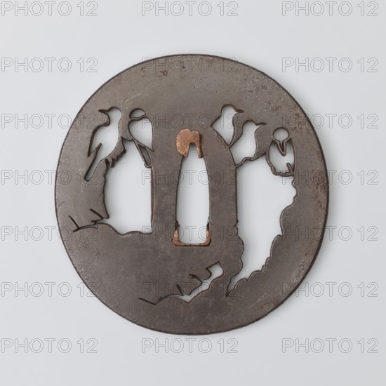 Crossguard tsuba, Higo school; maker Tokishige. Round tsuba maru gata with rectangular edge kaku mimi, sekigane made of copper. Decorated with a negative openwork composition showing birds sitting on a rock. Japanese, Edo 1603–1868, 18th century, tsuba for katana; diameter 7.4 cm, thickness 0.38 cm., A round metal object with a dark brown surface and areas of lighter brown and copper tones, featuring cutout silhouettes of birds perched on irregular branches and openings, with smooth edges and some rough worn spots, set against a pale gray background.