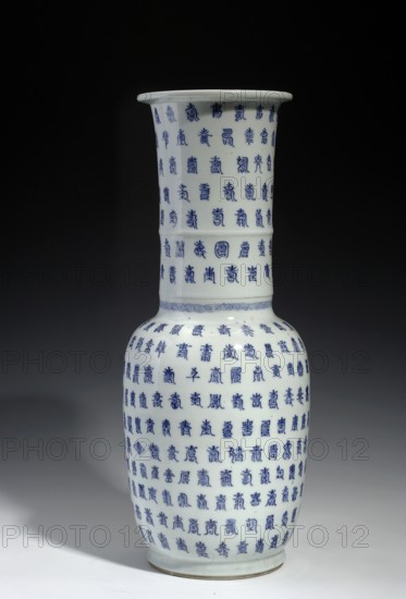 Vase, gift, Qing 1644–1911 style, Jiajing 1522–1566 influence, Chinese ceramics, blue-and-white porcelain with backdated signatures, cylindrical neck; 19th century, China; vessel; height 44.0 cm, diameter 17.5 cm., A white ceramic vase with a tall flared neck and rounded body sits against a dark background; it is covered in a dense repeating decorative pattern in blue, with the blue motifs arranged in horizontal rows that wrap around the vessel, and a narrow band of a different blue decorative motif separates the neck from the body. The visible colors in the image are white, blue, black, and shades of gray.