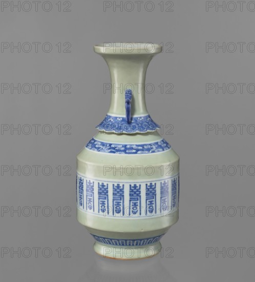Vase, Chinese, Qing dynasty 1644–1911, 19th century. Ceramic vessel with longevity shou and bat iconography, lambrequin pattern, geometric ornaments; neck separated by a ruff; two applied handles. Weight 3.55 kg; height 44.0 cm; diameter 22.0 cm., A tall ceramic vase with a narrow neck flaring into a wide rim sits against a plain gray background; the vase is primarily pale green with decorative bands and accents in blue, including a scalloped blue collar near the shoulder, a blue handle-like protrusion on the neck, a patterned blue band around the midsection, and a blue geometric band near the base; the surface is glossy and smooth, and the rim shows a slightly darker edge.