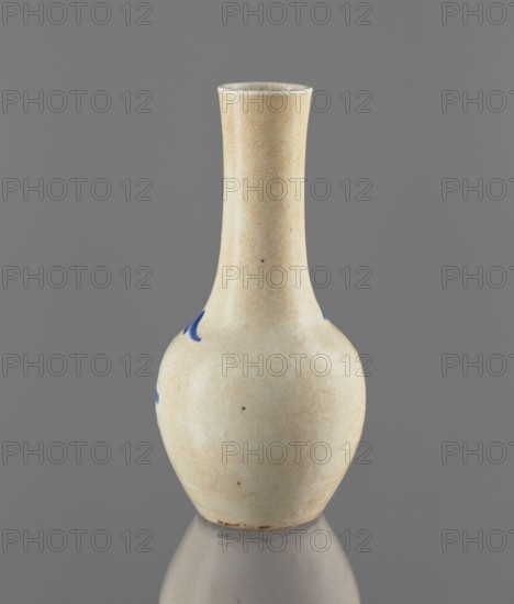Vase, gift, Chinese, Qing dynasty 1644–1911, 19th century; blue-and-white porcelain with cracklework decoration depicting fishermen and landscape motifs; vessel; height 23.9 cm, diameter 11.7 cm, weight 0.7 kg., A ceramic vase with a narrow tall neck and a rounded body sits against a solid gray background, showing a crackled pale beige glaze overall with a few small darker spots and a couple of irregular blue brush marks near the shoulder; the rim interior appears slightly lighter and the base shows some subtle brown discoloration, with the vase reflected faintly on the surface beneath it.