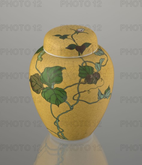 Ginger vessel with lid, Nagoya Shippô Kaisha 1871–1890. Japanese, Meiji period c. 1870–1880. Porcelain cloisonné totai-shippo technique, height 12.4 cm, diameter 9.6 cm. A small ovoid vase with a round flattened lid; outer surface covered with a lemon-yellow glaze with a decorative grid of crackles; interior and bottom are white covered with a transparent glaze. Decorated with a naturalistic bean-vine motif with greenish-brown leaves and pink flowers, loosely twining around the body and reaching the lid. Motif executed using cloisonné enamel with brass wires and multiple shades of green and brown; motif was carved into the surface before enameling totai-shippo. Signature in cobalt underglaze: Nihon Shippo Kaisha sei zo; overglaze iron-red rhombus cartouche with the sign sho presumed exporter’s mark. Around 1868 Tsukamoto Kaisuke 1828–1887 developed this porcelain cloisonné method; examples were also made by Takeuchi Chubei and Suzuki Seiichiro, and the object may possibly be by Takeuch...