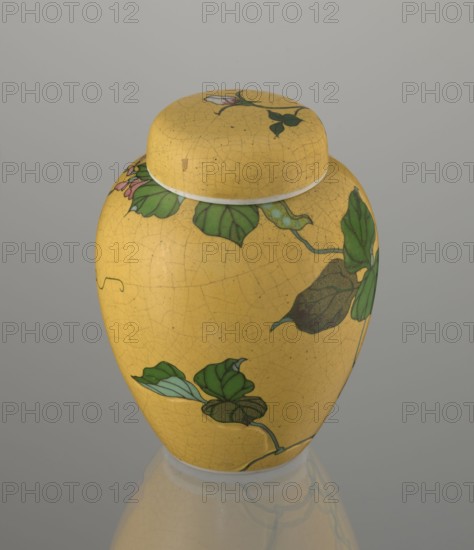 Ginger vessel with lid, Nagoya Shippô Kaisha 1871–1890. Japanese, Meiji period c. 1870–1880. Porcelain cloisonné totai-shippo technique, height 12.4 cm, diameter 9.6 cm. A small ovoid vase with a round flattened lid; exterior covered with a lemon-yellow glaze with a decorative crackled grid; interior and base are white covered with transparent glaze. Decorated with a naturalistic bean-vine motif of greenish-brown leaves and pink flowers, loosely twining around the body and reaching the lid. The motif was carved into the surface before filling with enamel and firing and executed using cloisonné enamel with brass wires and enamel in several shades of green and brown. Underglaze cobalt signature: Nihon Shippo Kaisha sei zo; overglaze red-iron rhomboid stamp with the sign sho presumed exporter’s mark. Around 1868 Tsukamoto Kaisuke developed this method of decorating porcelain with cloisonné; examples by Takeuchi Chubei and Suzuki Seiichiro and works from Nagoya workshops are known. Possibl...