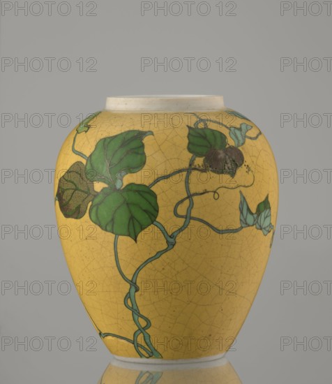 Ginger vessel with lid, Nagoya Shippô Kaisha 1871–1890. Japanese, Meiji period 1868–1912. Porcelain cloisonné totai-shippo technique, c. 1870–1880. Small ovoid vase with round flattened lid, height 12.4 cm, diameter 9.6 cm. Outer surface covered with lemon-yellow glaze with decorative crackle grid; interior and bottom white under transparent glaze. Decorated with a naturalistic bean-vine motif of greenish-brown leaves and pink flowers, executed in cloisonné enamel with brass wires and multi-shade green and brown enamels; the motif was carved into the surface before enameling. Maker’s marks: underglaze in cobalt “Nihon Shippo Kaisha sei zo” and an overglaze red-iron rhomboid cartouche with the sign “sho” presumed exporter’s mark. Attributed techniques and makers: porcelain cloisonné method developed by Tsukamoto Kaisuke 1828–1887; similar works by Takeuchi Chubei and Suzuki Seiichiro; possibly made by Takeuchi Chubei though unsigned., A rounded ceramic vase with a yellow ground showing ...