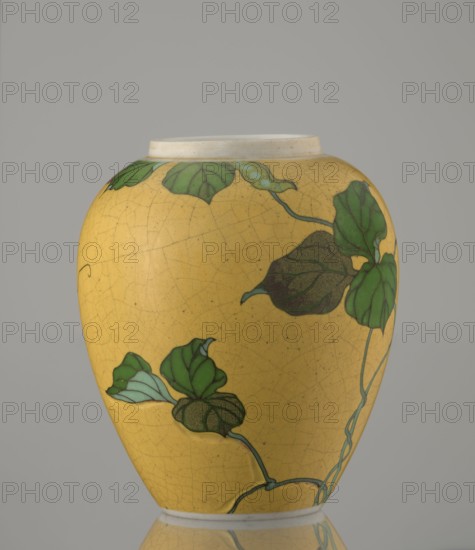 Ginger vessel with lid, Nagoya Shippô Kaisha ca. 1870–1880, Meiji period. Small ovoid porcelain vase with round flattened lid; exterior covered with lemon-yellow glaze with crackle grid, interior and base white under transparent glaze. Decorated with a naturalistic bean-vine motif of greenish-brown leaves and pink flowers executed in cloisonné enamel totai-shippo technique: decorative motif was carved into the surface before filling with enamel and firing, using brass wires and enamel in several shades of green and brown. Underglaze cobalt signature: Nihon Shippo Kaisha sei zo; overglaze red-iron rhomboid cartouche with sign sho. Porcelain cloisonné method developed by Tsukamoto Kaisuke 1828–1887 around 1868; also produced by Takeuchi Chubei and Suzuki Seiichiro; Takeuchi Chubei was among leading craftsmen employed by Nihon Shippo Kaisha. Possible attribution to Takeuchi Chubei though object is unsigned. Japan, Nagoya. Vessel; height 12.4 cm, diameter 9.6 cm., A rounded ceramic vase wi...