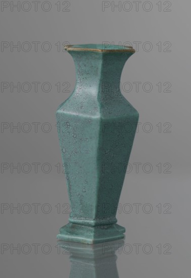 Vase, Qing style; ceramics; Chinese, Qing 1644–1911, 19th century; vessel; height 11.6 cm, width 4.7 cm, depth 7.15 cm., A tall hexagonal vase with a flared neck and a stepped base, shown standing on a reflective surface; the vase has a crackled glaze texture and is predominantly turquoise with darker teal speckling and subtle brownish accents along the rim and edges, set against a smooth gray background.