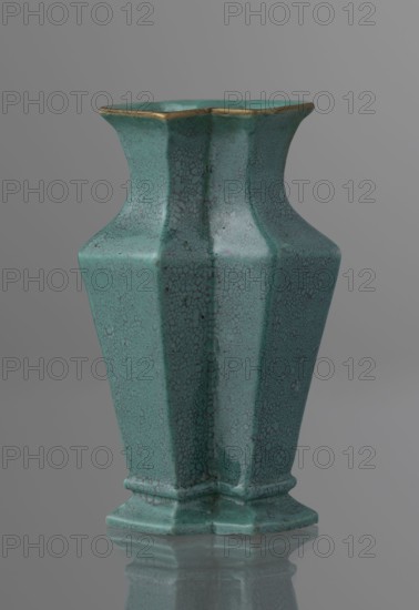 Vase, Qing style, ceramics, Chinese, Qing dynasty 1644–1911, 19th century, China; vessel; height 11.6 cm, width 4.7 cm, depth 7.15 cm., A ceramic vase with a hexagonal, flared shape sits against a neutral gray background, showing a crackled glaze in shades of turquoise and teal with darker speckled lines and small irregular spots; the rim has a thin band of metallic gold, and the base is slightly raised with a matching turquoise crackle finish that reflects faintly on the glossy surface below.