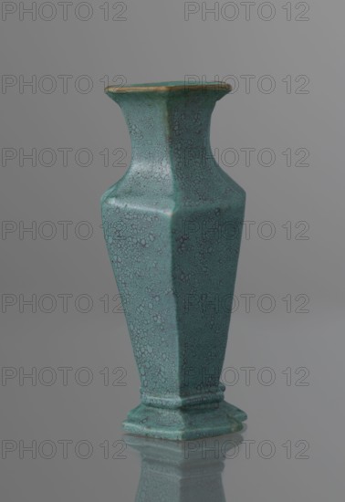 Vase, gift, Qing style, ceramics, Chinese art, Chinese culture, Qing 1644–1911, 19th century, China, vessel; height 11.6 cm, width 4.7 cm, depth 7.15 cm, A tall ceramic vase with a hexagonal profile standing on a reflective surface, finished in a turquoise-green glaze with a crackled, speckled pattern and darker flecks; the rim shows a thin band of brownish-gold, and the background is a smooth gradient of gray.