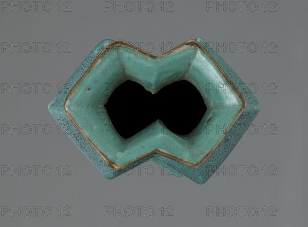 Vase, Qing style, Qing dynasty 1644–1911, 19th century, China; ceramics; Chinese art and culture; vessel; height 11.6 cm, width 4.7 cm, depth 7.15 cm., A close-up view of a turquoise ceramic object with a geometric, diamond-like opening showing a dark interior, the ceramic surface displaying mottled turquoise and green tones with areas of brownish-gold along the inner rim and small darker speckles and crackle patterns on the exterior, set against a plain gray background.