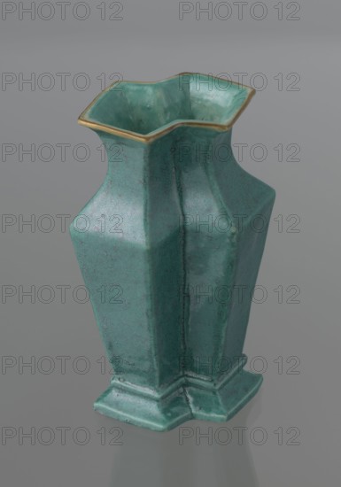 Vase, Chinese, Qing dynasty 1644–1911, 19th century. Ceramic vessel covered with a turquoise glaze with manganese spots. Height 11.6 cm; width 4.9 cm; depth 7.1 cm; weight 0.15 kg., A green ceramic vase with a glossy finish and a subtle speckled texture, featuring an angular, geometrical form that flares at the top into a scalloped rim edged with a thin band of metallic gold; the body narrows then widens into pronounced faceted sides and rests on a stepped base. The visible colors are green, gold, and shades of gray in the background and reflections.
