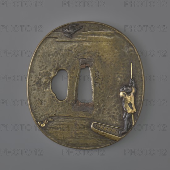 Crossguard tsuba, Tsuchiya Yasuchika 1670–1744. Oval tsuba tatemaru gata in copper with ryohitsu ana and sekigane; decorated in high relief using iro-e takazôgan inlay with various metals. Obverse: a fisherman in a boat pushing with a long pole and looking at a bird flying against the clouds. Reverse: reeds growing over the water and the moon emerging from behind the clouds. Edo period, 1st half of the 18th century Japan, Edo now Tokyo. Height 7.5 cm; width 6.9 cm; depth 0.4 cm., A rounded metal disc with an aged brass appearance showing areas of darker patina and lighter golden highlights, featuring a carved irregular central opening and a separate rounded cutout; a small sculpted figure with darker metal tones and golden clothing stands on a raised platform at the edge while holding a thin vertical rod, a small bird motif appears near the top on a textured background, and a few stylized water ripples and a small cluster of decorative elements are visible near the lower edge.