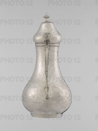 Teapot with a lid, Islamic art, Turkish, Ottoman dynasty 1299–1922, 19th century, Turkey; vessel for beverages teapot; materials/technique implied weight 300 g; height 20.3 cm; diameter 9.7 cm; decoration: geometric motifs and plant ornament., A single metal pitcher with a bulbous lower body tapering to a narrower neck and a domed lid topped by a small finial, shown against a plain light gray background; the pitcher has an attached curved handle running down the front, a hinged lid with a decorative hinge element, and surface engraving in floral and leaf patterns; the overall color is silvery gray with areas of slightly darker gray patina and subtle reflective highlights.