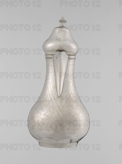 Teapot with a lid, Islamic art, Turkish culture, Ottoman dynasty 1299–1922, beverages, teapot, geometric motifs, plant ornament, 19th century, Turkey place of origin, vessel; weight 300 g, height 20.3 cm, diameter 9.7 cm, A metallic pitcher with a bulbous base tapering to a narrow neck and topped by a domed lid with a finial, shown against a plain light gray background; the pitcher is silver in color with subtle engraved floral and leaf patterns across its body, a defined spout projecting from the neck, a rounded base with slight wear marks, and the lid and shoulder areas showing gentle reflections and tonal variations of silver and gray.