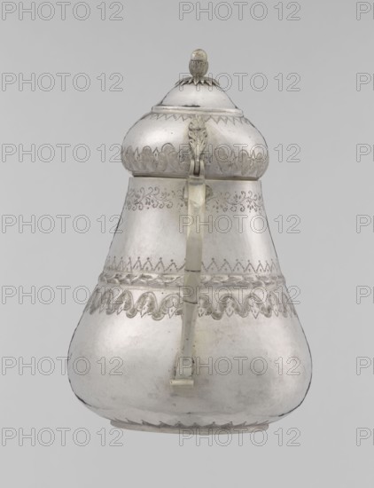 Teapot, teapot, Turkish, Ottoman dynasty 1299–1922; 19th century, Turkey; vessel; materials not specified; weight 320 g; height 17.0 cm; diameter 10.9 cm; decorative motifs: geometric motifs, plant ornament, zigzag, lambrequin., A pear-shaped metal vessel with a domed lid and a hinged handle is shown against a plain light gray background, displaying a reflective silver color with areas of darker patina and light wear; the lid has a rounded finial and a scalloped band at its base, the upper body features ornate engraved decorative bands and a repeating scallop motif, the midsection shows a braided or rope-like raised band and additional etched patterns, the handle extends vertically from near the lid to the lower body and appears slightly tarnished with visible joins, and the surface overall has a smooth metallic texture with subtle dents, scratches, and variations in sheen.