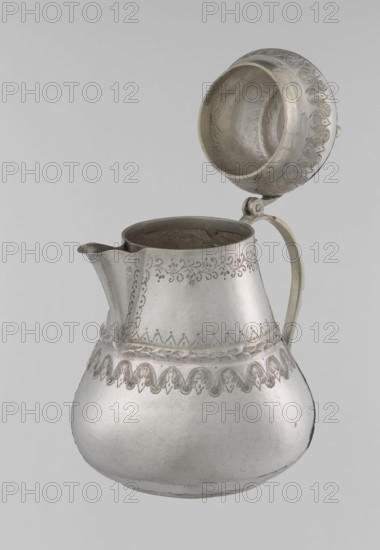 Teapot, 19th century; Ottoman dynasty 1299–1922; Turkish, Islamic art; vessel teapot/jug; materials not specified; decorated with geometric motifs, plant ornament, zigzag, lambrequin; height 17.0 cm, diameter 10.9 cm, weight 320 g; Turkey place of origin., A metal pitcher with a hinged lid shown open, with a bulbous lower body and narrower upper body, a curved spout on one side and a handle on the opposite side; the surface has engraved decorative patterns around the upper body and near the midsection, and the lid interior is visible with matching decorative detail; visible colors include silver, gray, and subtle darker gray areas from shading and wear, against a light gray background.