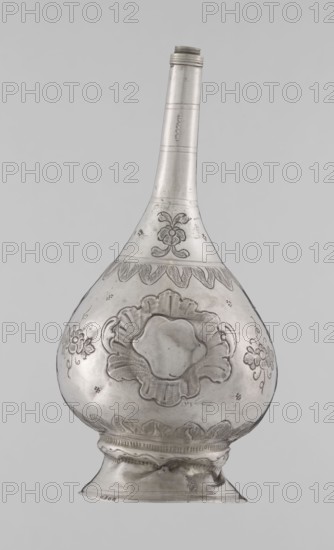 Bottle for spraying water soaked in perfumes, Islamic art, vessels, plant ornament, floral motifs; decoration: multi-leafed undecorated cartouches alternating with small flowers; 19th–20th century, possibly Turkey or North Africa; vessel; weight 113 g; height 17.5 cm; diameter 8.0 cm., A single metal vessel with a long narrow neck and a wide bulbous body is shown against a plain light gray background; the vessel is silver in color with darker etched decorative patterns including floral motifs and scalloped borders, and it sits on a flared foot with embossed and engraved ornamentation, showing subtle areas of shine and shadow on the metal surface.
