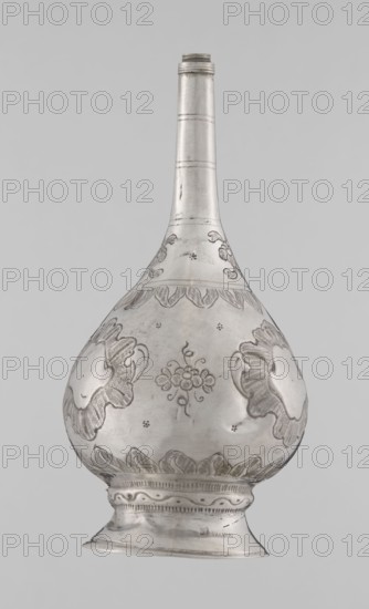 Bottle for spraying water soaked in perfumes, Islamic art, Islamic culture, vessel with plant and floral ornament; decoration: multi-leafed undecorated cartouches alternating with small flowers. 19th/20th century, possibly Turkey or North Africa. Weight 113 g, height 17.5 cm, diameter 8.0 cm., A metallic vessel with a long narrow neck and a bulbous body standing on a flared foot, shown against a plain light gray background; the vessel is silver in color with engraved decorative motifs including floral and leaf-like patterns and textured shaded areas, with several scalloped border designs around the widest part and base, and the surface shows subtle scratches and variations in sheen.