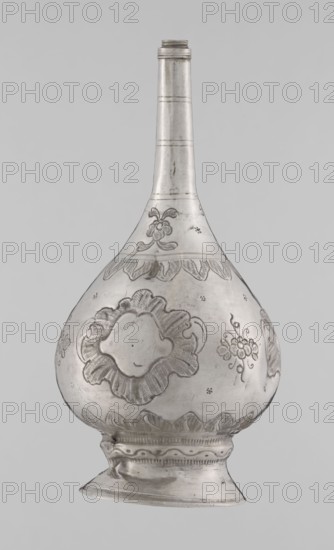 Bottle for spraying water soaked in perfumes, creator unknown, Islamic art, Islamic culture; vessel decorated with plant ornament and floral motifs: multi-leafed undecorated cartouches alternating with small flowers. 19th/20th century, possibly Turkey or North Africa; weight 113 g, height 17.5 cm, diameter 8.0 cm., A single metallic vessel with a tall narrow neck and a bulbous body stands against a plain light gray background; the surface of the vessel is silvery with darker engraved decorative patterns including floral motifs and scalloped borders, a flared foot supports the rounded form, and the metal shows subtle variations in tone with a few small darker spots and fine textural details from engraving.
