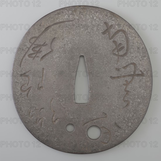 Crossguard tsuba, Korekazu,  school author, Amida iconography, sword crossguards, katana, Japanese art, Buddha iconography, Japanese culture, Edo 1603-1868, weapon, bladed weapons, inscriptions, Buddhism. Oval tsuba tatemaru gata with a rectangular edge kaku mimi. In the lower part there are two holes udenuki ana for threading the ribbon. The surface of the shield is decorated on both sides with an inscription engraved in cursive script. On the obverse, an invocation to Amida Buddha: Namu Amida butsu praise be to Amida Buddha; on the reverse, the inscription: Iki sugi tarinari kono otoko this man has lived too long. Signed. 17th century Edo period 1603-1868 Enpô era 1673-1681, Japan, Ômi Eshu province, tsuba, height 9.1 cm, width 8.6 cm, depth 0.3 cm., A circular metal object with a rough, mottled surface in shades of grey and brown, featuring a central elongated triangular opening and two smaller round holes near the bottom edge, with shallow carved or incised curved lines and marks d...