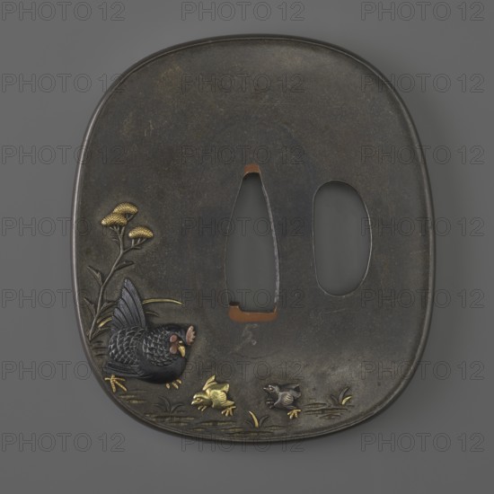Crossguard tsuba, Suiyôdô, Toshimasa, Japanese, Edo period 1st half of the 19th century. Tsuba in the shape of a rectangle with rounded sides nadegaku gata, katahitsu ana; copper sekigane fillings. Decorated on both sides with high-relief decoration inlaid with multicolored metals, depicting on the obverse a rooster by a fence overgrown with bindweed and a chicken in the grass among flowers; on the reverse a hen with two chicks. Materials: metals multicolored inlay, copper sekigane. Dimensions: height 6.6 cm, width 5.8 cm, depth 0.3 cm. Subjects/iconography: plants, flowers, animals, birds, hens, roosters, chicks, chrysanthemums, morning glory, wolfberries., A dark, oval metal plate with a smooth, slightly textured surface and a central pair of irregular openings, featuring a decorative scene near the lower left with a black bird with detailed feather texture, a few small birds in gold and dark tones, stylized grass and plant elements in gold and dark green, and a vertical stem with go...
