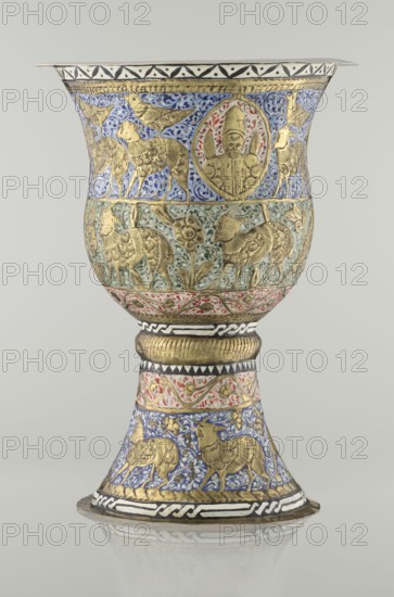 Cup, Persian, Qajar dynasty 1785–1925, 19th century, Iran. Vessel cup, height 25.5 cm, diameter 18.4 cm. Decoration: cartouches with a bust of a man, animals lions, birds, figures, flowers, geometric and small plant ornament; figurative motifs., A decorated goblet-shaped vessel with a flared rim and a flared foot standing on a reflective surface, featuring ornate embossed and painted ornamentation in gold, blue, green, red, white, black, and cream; the upper bowl area shows a band of blue background with gold animal figures and a central circular medallion containing a gold humanlike figure surrounded by red and green accents, while a lower band on the bowl has a greenish background with gold animals and floral motifs; the stem and foot display alternating decorative bands including a ribbed gold collar, a cream band with red scrolling foliage, and a blue band with gold animal figures, all separated by black-and-white geometric borders, with finely textured gold detailing throughout an...