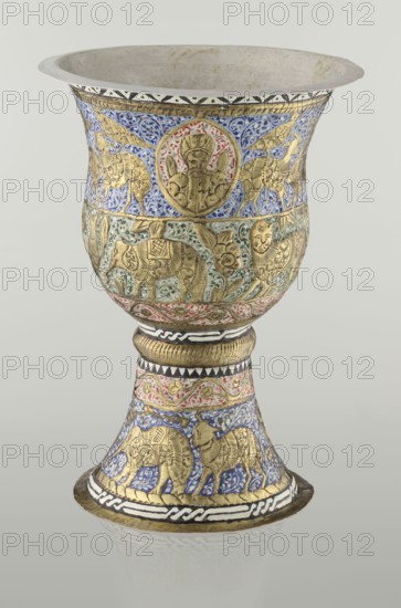 Cup, Persian, Qajar dynasty 1785–1925, 19th century, Iran; vessel, height 25.5 cm, diameter 18.4 cm. Decoration: cartouches with a bust of a man, animals lions, birds, figures, flowers, geometric and small plant ornament; figurative motifs., A decorative goblet-shaped vessel with a flared rim and a pedestal base, featuring embossed gold figures and patterned enamel work in blue, green, red, black, white, and gold; the upper bowl shows a round medallion with a human bust surrounded by blue and red ornament and flanked by winged creatures in gold on a blue background, while the midsection displays gold animal figures amid green and red floral scrolls, and the lower stem and base repeat blue enamel backgrounds with gold animal motifs and bands of black and white geometric patterns.