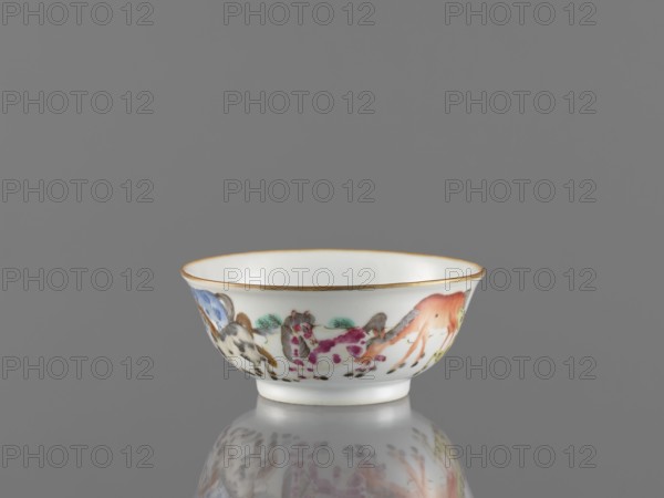 Bowl, ceramics, colored porcelain, Qing style, Chinese art, landscape motifs, Chinese culture, horses, bowl on a ring-shaped foot, decorated on the outer wall, 19th century, China, vessel, height 5 cm, diameter 11.8 cm, A small white porcelain bowl with a thin gold rim sits on a reflective gray surface against a gray background; the exterior of the bowl is painted with a group of colorful stylized animals and plants in shades of orange, pink, blue, green, black, and brown, and the bowl's interior is plain white.