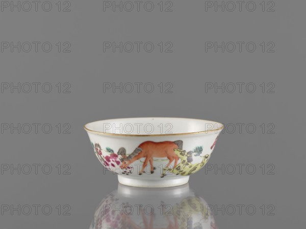Bowl, ceramics, colored porcelain, landscape motifs, Qing style, Chinese art, Chinese culture, horses, bowl on a ring-shaped foot, decorated on the outer wall, 19th century, China, vessel, height 4.8 cm, diameter 11.7 cm, A small white porcelain bowl with a thin gold rim sits on a reflective grey surface against a grey background; the bowl's exterior is decorated with colorful painted motifs including an orange-brown animal, a yellow-green animal, pale green foliage, and clusters of pinkish-red flowers, with accents of black and soft brown in the detailing.
