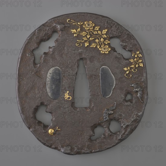 Crossguard tsuba, Edo period 18th century, 1603–1868, Japan. Oval tatemaru gata tsuba with an irregular edge and a surface textured to imitate rock, cut into openwork irregular elongated holes. Inlaid in high relief with a motif of a blooming rose bush, a snail, and flying bats. Signed in flat gold inlay: italic character ju naga. Dimensions: height 8.0 cm, width 7.5 cm, depth 0.5 cm., A round dark brown metal object with an irregular textured surface and several rough holes, decorated with a few gold floral motifs and leaves near the top and right edge, two smooth dark gray oval insets near the center, a narrow vertical triangular opening in the middle, a small gold spiral shape near the lower left, and a few small dark gray raised details on the right side; visible colors include dark brown, gold, dark gray, and gray.