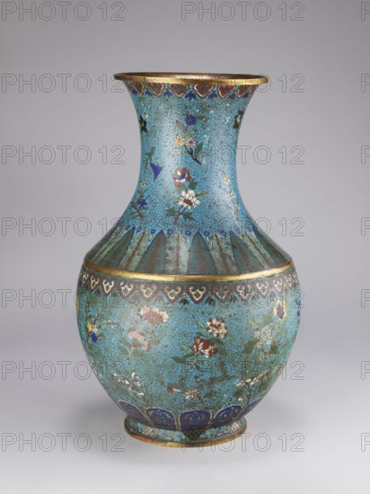 Vase, Qing style, Chinese culture, Chinese art, Qing 1644–1911; 18th/19th century; porcelain vessel with a thick cylindrical neck and flared spout; decorated with chrysanthemums, peonies, plum trees, meander ornament and plant motifs; height 61.5 cm, diameter 25.7 cm, weight 10.0 kg., A decorative vase with a flared neck and rounded body sits against a neutral background; the surface is predominantly turquoise with intricate darker turquoise geometric patterns and scattered floral motifs in colors including white, red, pink, blue, green, and gold; the rim and narrow bands are metallic gold; a band of dark blue and green leaf-like shapes encircles the shoulder, and a row of dark blue scalloped shapes with gold accents appears near the base; the vase shows areas of patina and slight wear on the colored enamel.