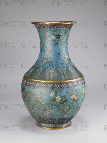 Vase, Chinese, Qing dynasty 1644–1911, 18th–19th century. Porcelain vessel with a thick cylindrical neck and a flared spout, decorated with chrysanthemums, peonies, plum trees, meander ornament and plant motifs. Height 61.5 cm; diameter 25.7 cm; weight 10.0 kg., A decorative vase with a rounded body and a flaring neck sits against a plain light gray background. The vase surface is predominantly turquoise with areas of blue, green, gold, red, white, pink, and black used in intricate painted and enamelled floral and geometric patterns. A band of gold accents rings the rim and another gold band encircles the shoulder. The upper neck shows a repeating geometric maze-like pattern in turquoise and darker blue with small scattered floral motifs in white, black, pink, and blue. Below the shoulder is a row of stylized feather- or petal-like motifs in green and blue edged with gold. The body of the vase features scattered floral sprays and blossoms in white, pink, yellow, red, blue, and green, s...