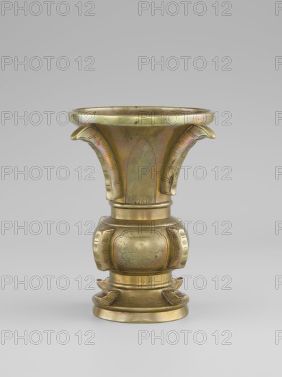 Gu-type vase, Vase with a shape inspired by the cult vessel gu, with four convex, interrupted strips. Decoration: on the belly in oval reserves stylized peonies on a grained background., Chinese, Qing 1644–1911, Qing style; ceremonial/ritual vessel. 19th century, China. Height 16 cm, diameter 12.2 cm., A metallic vessel with a flared rim and a bulbous midsection stands against a neutral gray background; the surface shows a polished brass-like color with subtle iridescent hues of green and pink, and the form includes curved, petal-like projections on the upper flared area and decorative rounded panels on the midsection, with carved lines and shallow relief patterns visible on the base and body.