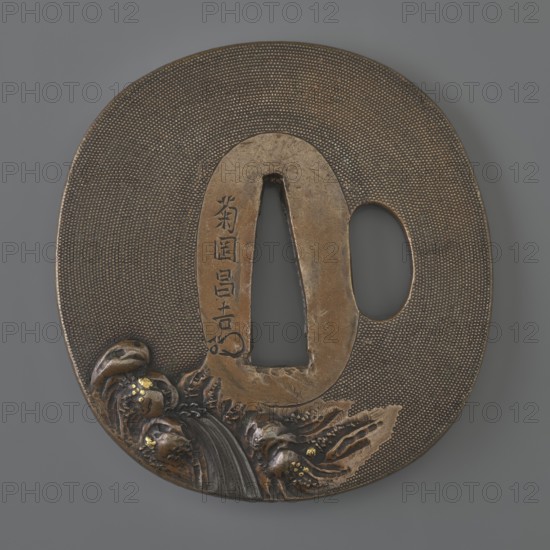 Crossguard tsuba, Kikuoka Masayoshi; Kikuoka school. Oval tsuba tatemaru gata with a rectangular edge kaku mimi, katahitsu ana, oval seppa dai. Decorated in high relief using the iro-e takazôgan technique inlaying with multicolored metals on a grained nanako background. Obverse: two karashishi Chinese lions by a rock; reverse: a waterfall flowing among rocks. Signature on the reverse. Japan, Edo period, 1st half of the 19th century. Materials: metal; function: sword crossguard tsuba. Dimensions: height 6.8 cm, width 6.3 cm, depth 0.3 cm., A round metal object with an oval cutout and a vertical triangular opening, shown against a gray background. The surface is textured with a pattern of small raised dots and has a warm brown and dark bronze patina. Along the lower edge there is a raised decorative scene with flowing carved forms, including curved elements and a flowing band that resembles a cascade, with small accents of brighter gold-colored highlights. A smooth, slightly lighter-tone...