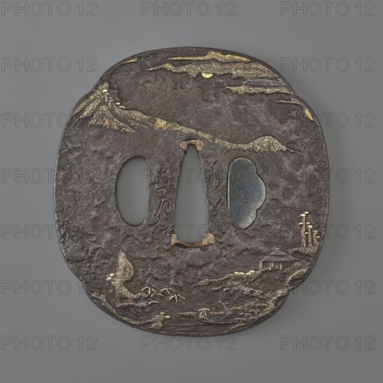 Crossguard tsuba. Maker: Jakushi; Kizaemon. Tsuba in the shape of a mokkô quatrefoil, with a kôgai hitsu hole plugged with shakudô, copper sekigane, textured surface ishime ji. Decoration in low relief hirabori with fine details inlaid with gold, using nunome technique in places, and copper. Both sides show a Chinese-style mountainous landscape with human and architectural staffage, including mountains, bamboos, pine trees, and bridges. Signed. 18th century Edo period, 1603–1868. Japan, Nagasaki, Hizen. Function: katana sword crossguard. Dimensions: height 7.6 cm; width 6.0 cm; depth 0.4 cm., A roughly oval, dark brown metal object with a textured, pitted surface and a few irregular cutouts in the center, showing a matte gray background through them; the piece has scattered areas of gold-colored inlay forming linear and patchy highlights along the top edge and parts of the lower half, and there are small raised and engraved motifs suggesting natural shapes across the surface rendered i...