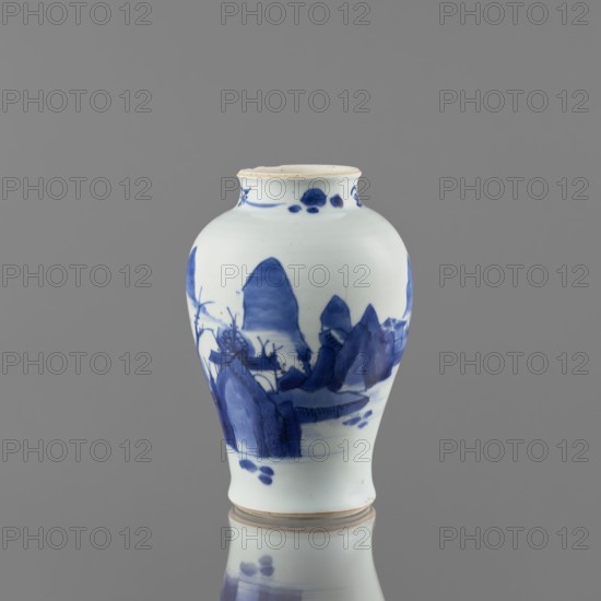 Meiping-type vase, ceramics, Meiping vessel type, blue and white porcelain, Qing style 1644–1911, decorated with landscape motifs including rocks, trees, and a pagoda; neck decorated with small plant motifs, Chinese art, pagodas, vase with a short neck, 1662–1722, China, vessel, height 17.7 cm, diameter 11.8 cm, A small ceramic vase sits against a gray background, predominantly white with blue painted designs; its shape is rounded with a narrow neck and slightly flared rim, and there is a reflection of the vase on the surface beneath it. The blue decoration depicts stylized landscape elements wrapping around the body, including mountain-like forms and organic shapes, with more concentrated blue areas near the middle and base and small blue accents near the neck. The rim shows a slightly off-white or beige edge, and the overall colors visible are white, blue, gray, and a touch of beige.