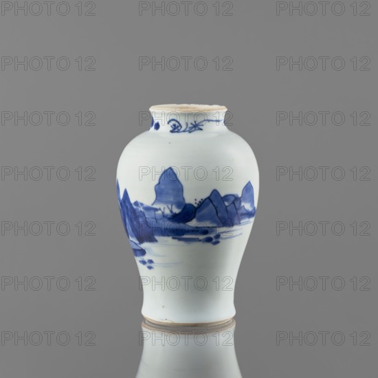 Meiping-type vase, ceramics, Meiping vessel type, blue and white porcelain, Qing style, 1662–1722, Chinese, decorated with images of rocks, trees, and a pagoda; neck decorated with small plant motifs; short neck, height 17.7 cm, diameter 11.8 cm, made in China., A small rounded ceramic vase with a narrow neck and slightly flared rim sits against a plain gray background, predominantly white in color with blue painted landscape motifs wrapping around its midsection; the blue decoration shows mountain-like shapes, horizontal brushstrokes suggesting water, and a few darker spots, while the rim and base have a light beige edge and the vase is reflected faintly below, showing the same white, blue, and beige tones.