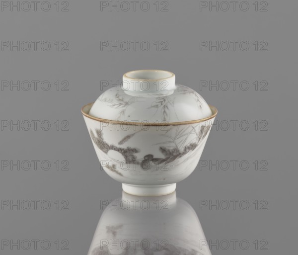 Bowl with a lid, decorated ceramics colored porcelain, Chinese art, Qing dynasty, Tongzhi 1862–1874; bowl on a ring foot with a lid-stand; exterior painted with a duck among reeds in a delicate black line and an inscription; lid painted with a branch bearing peach fruit; 1862–1874; China; vessel; height 9 cm, diameter 10.3 cm., A white porcelain covered bowl sits centered against a gray background, displaying a rounded lid with a short cylindrical knob and a flared rim edged in a thin gold band. The bowl body flares outward from a small foot and is also trimmed with a thin gold line along the top. Delicate gray-brown painted scenes encircle the bowl, including a scene with a bird among stylized plants and foliage, and additional fine botanical sketches on the lid. The surface of the bowl is glossy and reflects softly onto the smooth gray surface beneath it, creating a mirrored, slightly blurred reflection of the vessel. The visible colors are white, gray, brown, gold, and subtle darker...