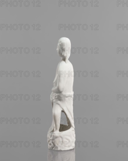 Adam figurine; creator, purchase provenance noted; Chinese; Chinese art; subject: Adam Bible, male figurine; Figure of a half-naked Adam; 17th–18th century; China; sculpture; height 20.3 cm, width 7.0 cm, A white glazed ceramic figurine of a standing person viewed in profile against a neutral gray background, showing smooth rounded features and a hood or hair shape at the head, with arms bent near the torso and a draped garment that falls to a decorative base with swirling patterns; the figurine casts a faint reflection on the surface below and the visible colors are white and shades of gray.