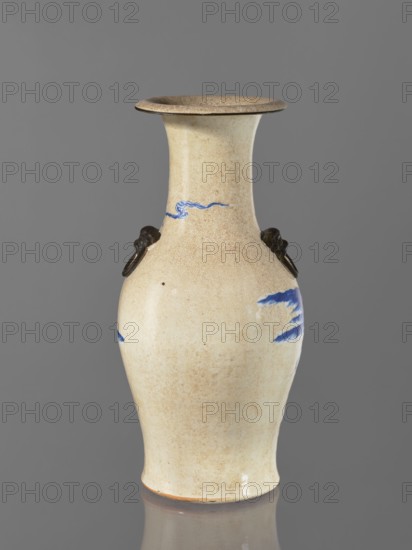 Vase, Chinese, figurative scenes, ceramics, blue and white porcelain, cracklework decoration, landscape motifs, Vase from a pair; ovoid, tapering towards the bottom, 19th century, China, vessel, height 53 cm, A ceramic vase with a flared rim and a gently curving body, displayed against a gray background; the vase surface is a crackled cream to beige with areas of light brown speckling, and it has a few small blue painted brushstroke motifs. The vase features a pair of dark brown ring handles attached at the shoulder. The rim interior and edge show a slightly darker brown tone, and the base edge has a subtle warm orange-brown line. The overall scene includes reflections of the vase on a glossy surface beneath it.