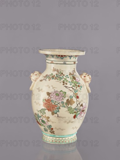 Vase, flowers, satsuma, Japanese art, vases, Japanese culture, ceramics, cracklework decoration, lions, floral decorations, peonies, chrysanthemums, plum trees, Meiji 1868–1912, ca. 1870–1880 Meiji 3–13, Japan, vessel, height 26.5 cm, width 17.5 cm, diameter 16.5 cm, An off-white ceramic vase with a wide flared rim and a rounded body sits against a muted gray background; the vase is decorated with painted floral branches featuring flowers in shades of pink, red, green, and teal with brown stems and golden-brown accents, and it has a turquoise band and patterned base in turquoise and red tones; there are sculpted animal head handles on each side in a pale beige with reddish details, and a decorative band of small colorful motifs runs beneath the rim.