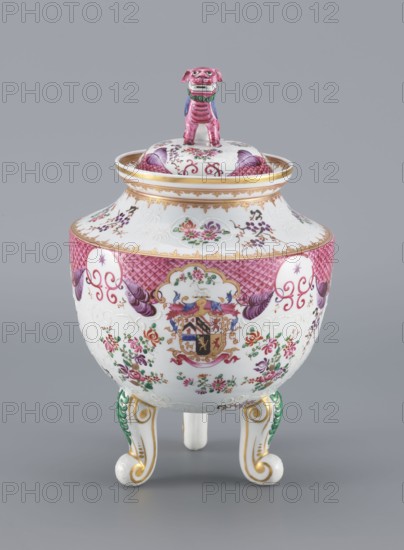 Vase with a Lid by Edmé Samson 1810–1891, porcelain, Chinese-style decoration with European influences; lid topped with a modeled lion figure. Features plant decoration, coats of arms, stylization, and fo iconography. 19th century, France. Vessel. Height 29.8 cm; diameter 18.5 cm. Repossession/provenance: Silesia., A lidded porcelain vessel with a glossy white base decorated with floral motifs in pink, green, purple, and gold, featuring a rounded body standing on three scroll-shaped feet painted with green and gold accents; the upper rim and lid edge have gold bands, the midsection displays a band of pink lattice pattern and purple ornamental swags, the body is adorned with painted bouquets and small floral sprays in pink, purple, and green, and the lid is topped by a small sculpted dog figurine painted pink with green and blue details.