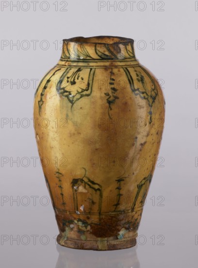 Vase, repossession Glogów, Islamic art, Persian, glazed ceramic utility vase with lambrequin pattern, 18th century, Iran; vessel, height 31.5 cm, diameter 19.7 cm, A yellow ceramic vase with a rounded body and narrow neck sits against a pale gray background; the vase shows a glossy surface with darker yellow and brown mottling and areas of wear, green decorative brushwork in floral and curved motif bands near the neck and lower body, a few small chipped spots revealing lighter underlying material, and a brownish base with traces of green glaze.