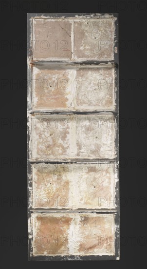 Panel of 10 tiles with plant decoration, Islamic art, Persian Qajar dynasty, 1785–1925, ceramics, plant ornaments, floral design with tulips and carnations, 18th–19th century, Iran; height 172.0 cm, width 64.0 cm., A tall rectangular panel divided into stacked rectangular compartments showing worn, rough surfaces with peeling layers and patchy textures in shades of beige, tan, off-white, cream, pale brown, and muted gray, framed by a dark charcoal border; several compartments have irregular white streaks and smudges, small round indentations, thin cracks, and areas of thicker plaster-like material, with scattered darker brown and rusty spots and subtle ochre and pinkish tones across the weathered surfaces.